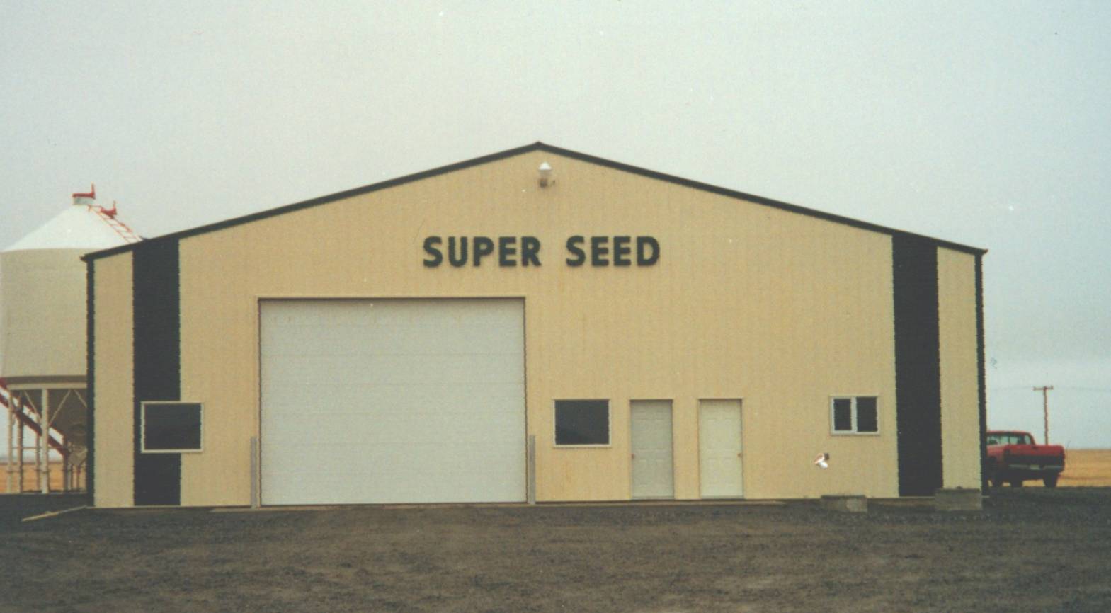 Super Seed farm building in Yellow Grass, Saskatchewan, representing an agriculture company with a large garage and entry doors in an agricultural setting.
